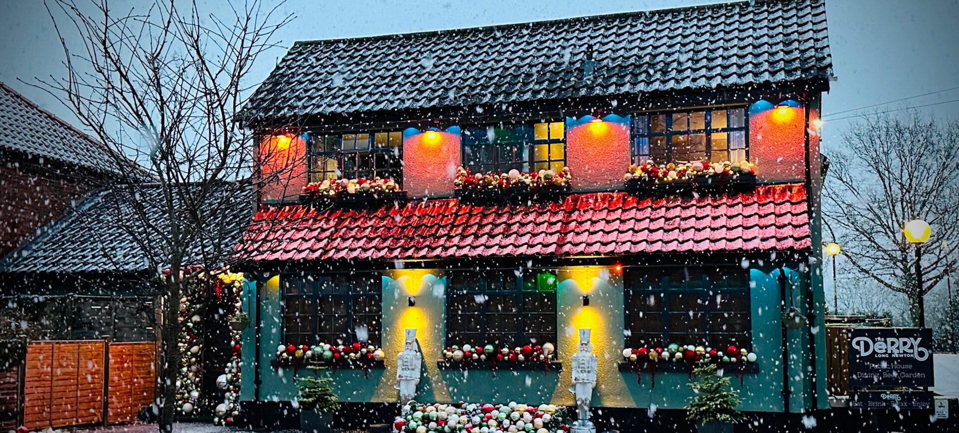 Snow-covered house adorned with holiday lights