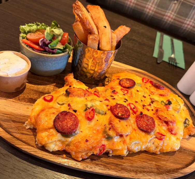 Delicious chicken parmo meal on wooden board