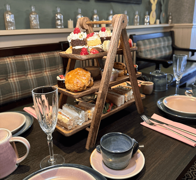 Tiered wooden tray with afternoon tea pastries